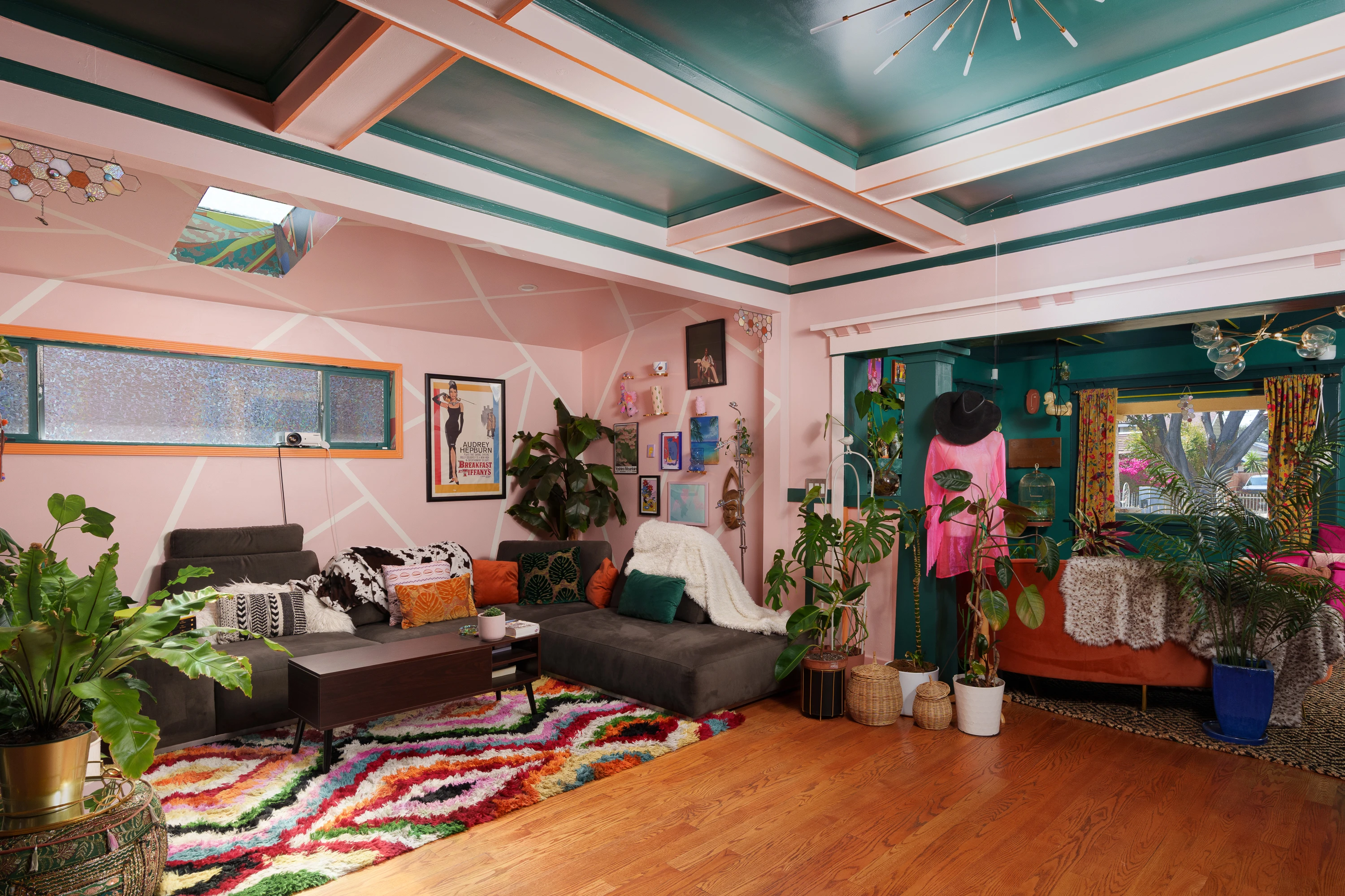 Eclectic living room with blush walls beneath a coffered teal ceiling